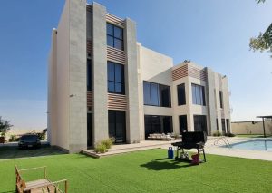 Rear Garden Film Location captures a serene outdoor setting, featuring a well-maintained building surrounded by lush greenery and a pool