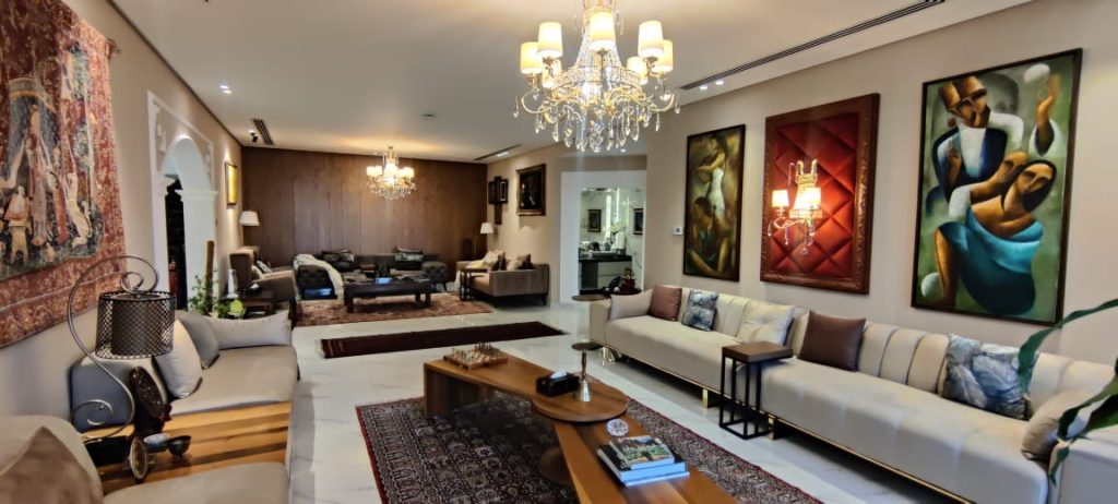 Picture showing both seating areas. Two stunning spaces in one villa – a modern Majlis with elegant sofas, art & chandelier, plus a cosy family room perfect for lifestyle shoots.